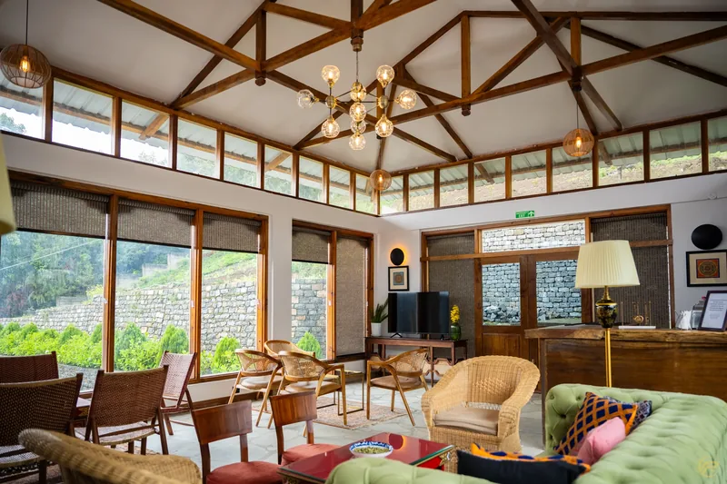 The bar, cane chairs and the valley through floor-to-ceiling glass