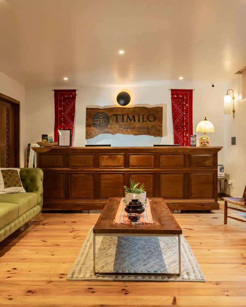 Reception at Timilo — a hand-carved desk under the carved Timilo sign