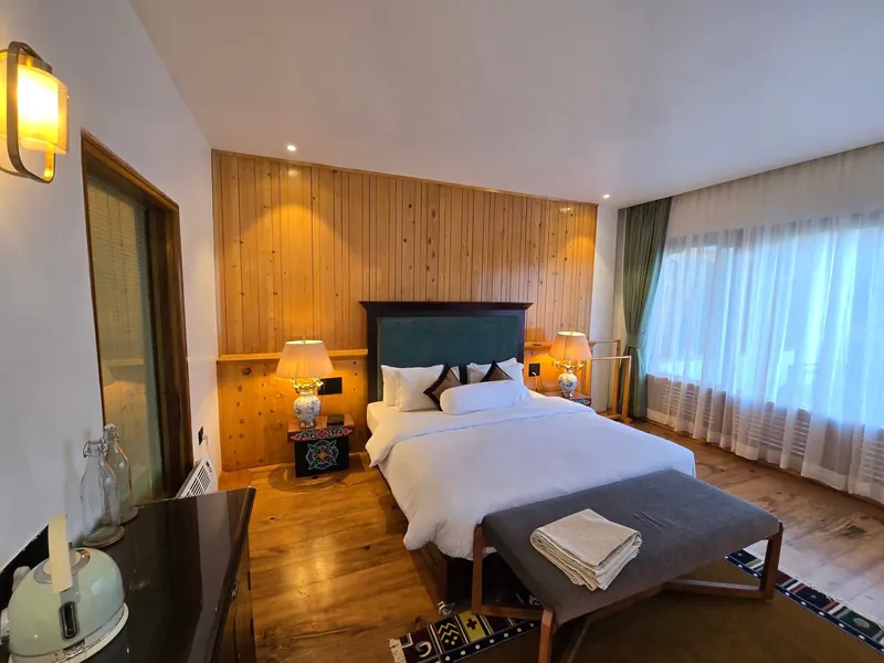 The bench at the foot of the bed, and the writing desk past it — Timilo Classic, Timilo Boutique