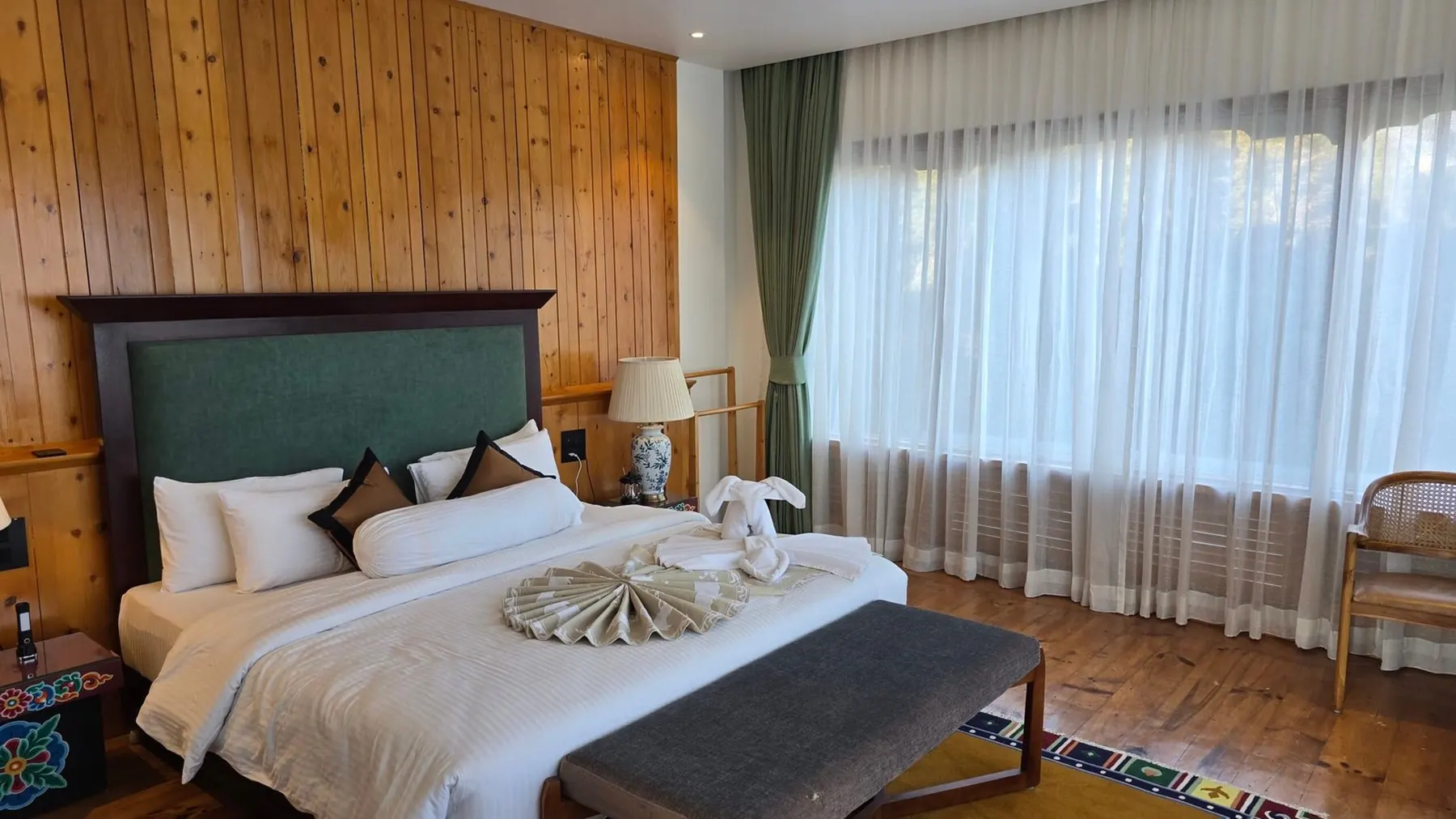 The Timilo Classic — a king size bed under a green headboard, with curtains falling to the floor
