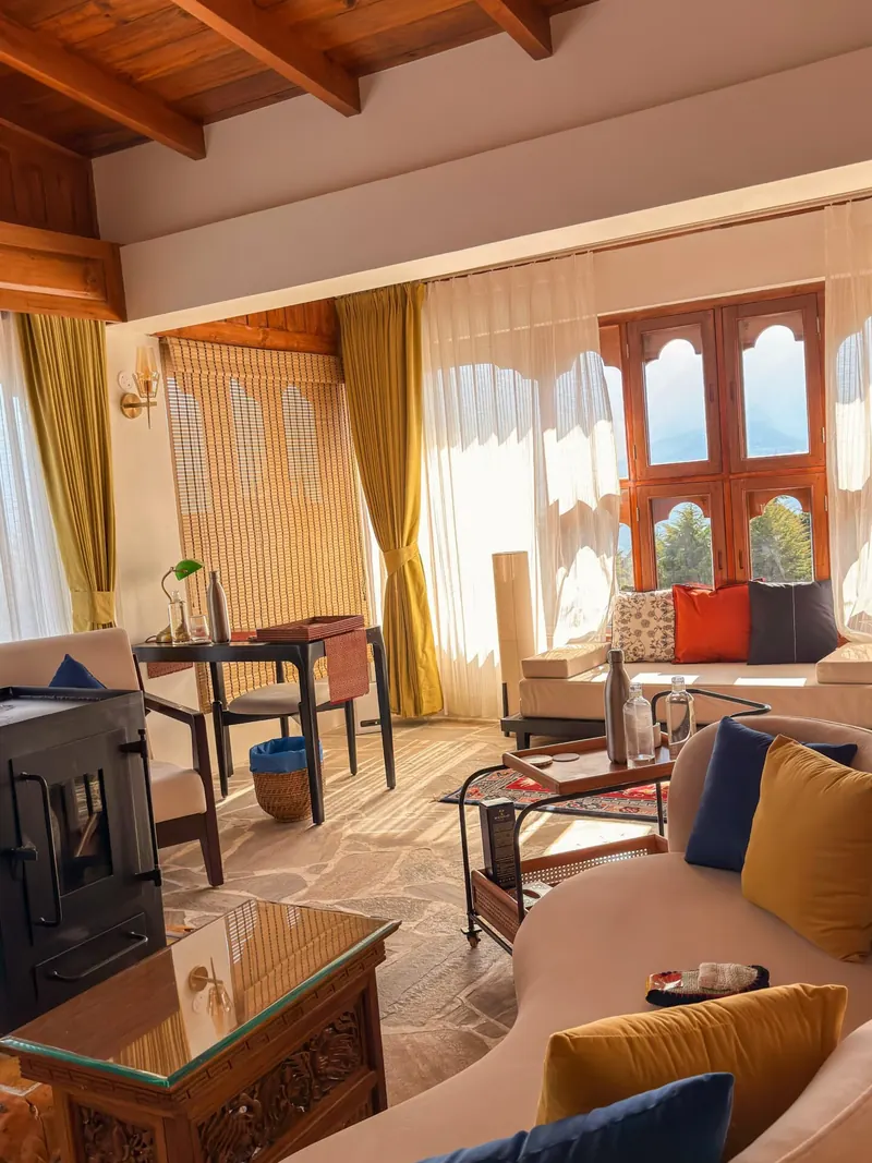 Lounge chairs drawn up to the window wall — Presidential Suite, Timilo Boutique