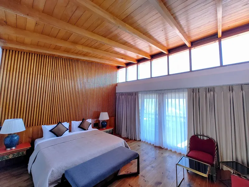 Vertical wood slats along the far wall, curtains drawn back onto the view — Timilo Royal Double, Timilo Boutique