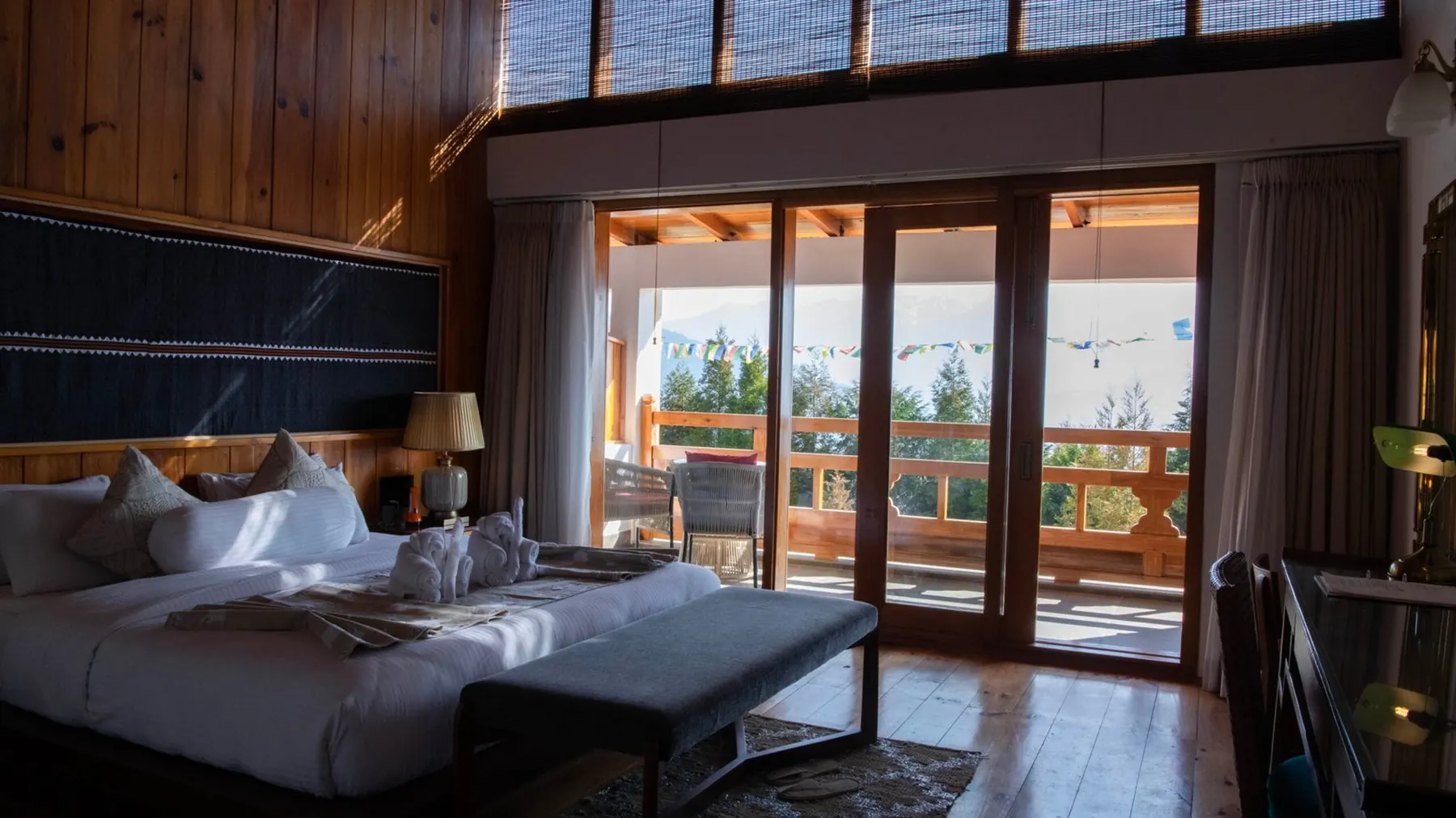 The Timilo Royal Double — beds made up in white linen with the balcony doors open onto the valley behind them
