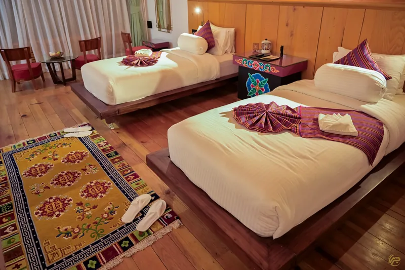 Both beds dressed and ready, patterned rugs underfoot — Timilo Royal Twin, Timilo Boutique